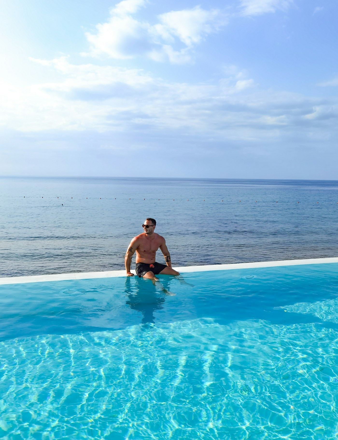 Man relaxing by an infinity pool overlooking the Mediterranean Sea, Northern Cyprus